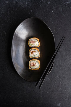 Delicious fried sushi rolls on plate in restaurant