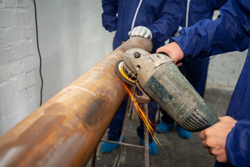 New employees of the company are trained to work with a circular grinder for the repair of pipelines for the supply of water to the city's homes.