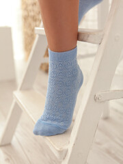 Girl in blue cotton socks. Natural
