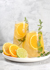Detox drink with lemon, mint, lime and orange on a light table, a cocktail improves metabolism and promotes weight loss, healthy lifestyle concept,