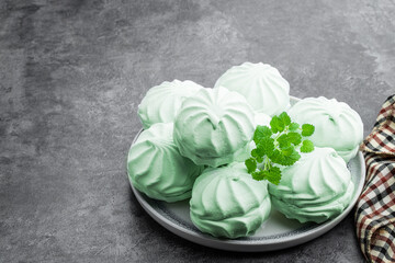 Mint marshmallows on ceramic plate on gray background