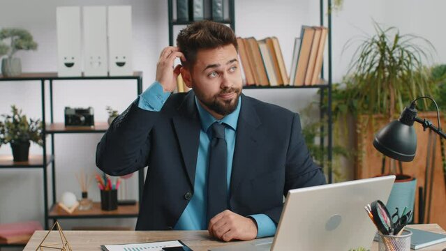 I dont know what to say. Confused business man working on laptop at office workplace. Freelancer feeling embarrassed about ambiguous question, having doubts, no answer idea, being clueless, uncertain