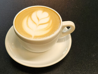 Coffee in a cup on a black background. Brewed coffee in a porcelain cup. Coffee advertisement