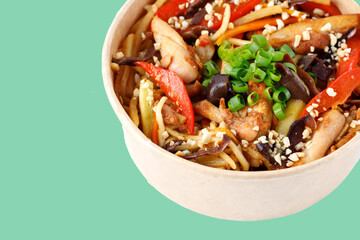 pasta with tomatoes, peppers and fried meat on a green background, studio shot 1