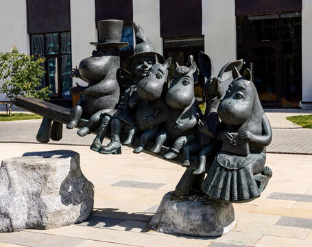 Moomins (mummy trolls) on the bench sculpture from classic children's literature books installed in the Tove Jansson's square in Scandinavian residential district	