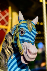 Fototapeta na wymiar Colorful horse on traditional old french caroussel in city park in sunny day