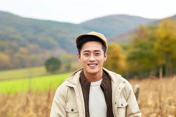 Young korean male farmer smiling and working in a farm field portrait