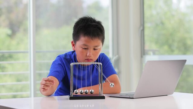 12 Year Old Boy Plays With A Newton's Cradle. Slow Motion.