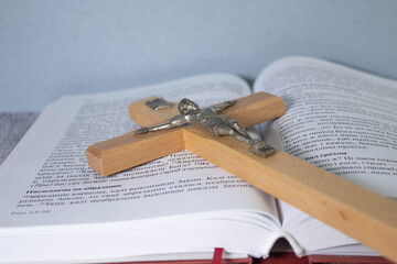 Wooden cross, Holy Bible and white lily on table