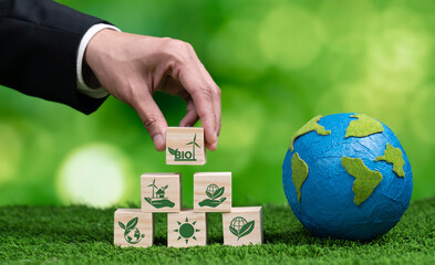 Hand of businessman holding Earth, symbolizing green business utilizing biofuel technology and...