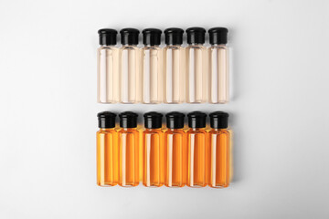 Bottles of cosmetic products on white background, flat lay