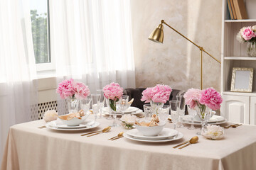 Stylish table setting with beautiful peonies and fabric napkins indoors