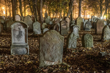 Tombstones in an old cemetery at night. - 634218386