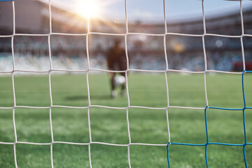 Young african american man holding soccer ball against soccer goal net © Katsiaryna
