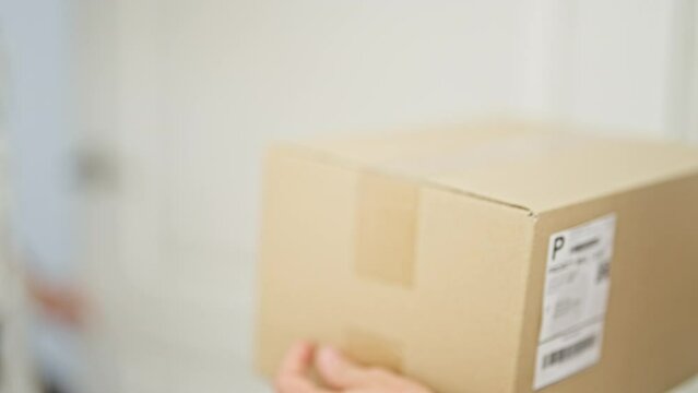 Middle age woman receiving package paying with dollars at home