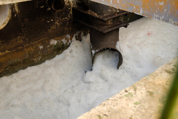 Untreated water into a river. Bad, dirty, untreated water flows from a pipe. environmental pollution by wastewater.