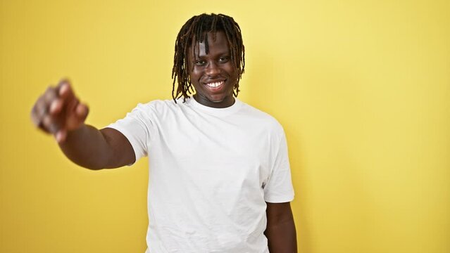 African american man smiling confident doing military salute over isolated yellow background