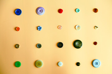 various types of buttons layed out on an orange background
