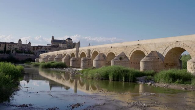 a low angle afternoon view of the ancient roman bridge and the mosque-cathedral of cordoba,spain