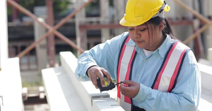 African american women foreman checking quality of prefabricated concrete wall. Plus size female worker wearing safety hardhat working at heavy Prefabricated concrete walls manufacturing factory