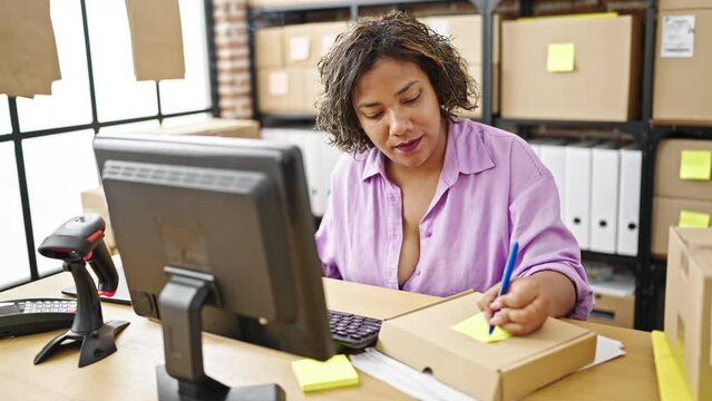 Young beautiful latin woman ecommerce business worker smoking cigarette working at office