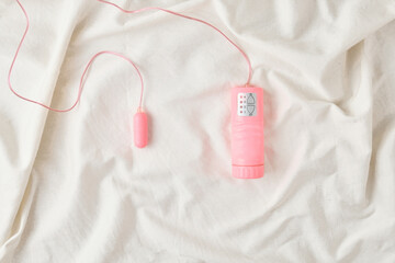 Pink sex toy on the bed. - obrazy, fototapety, plakaty