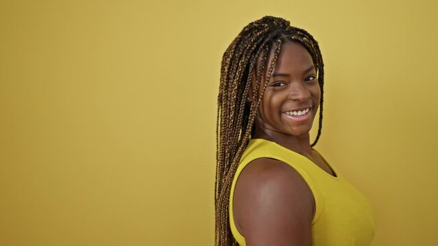African american woman smiling confident standing over isolated yellow background