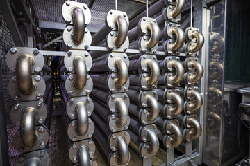 Industrial pipeline elbow system. Large, thick exchanger stainless steel pipes. Bent pipes are...