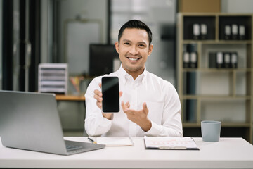 Successful business man, excited young man Keeping up arms and showing positive emotions, happy working in modern office on smartphone.