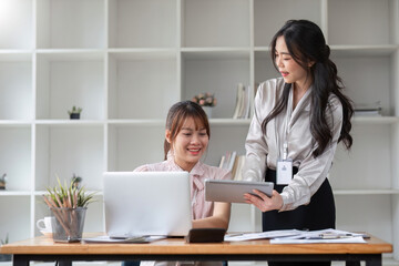 Two Young Asian businesswoman discuss with new startup project Idea presentation, analyze statistics and investment market at office