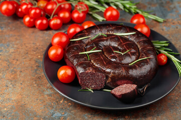 Black pudding or blood sausage with rosemary and tomatoes.
