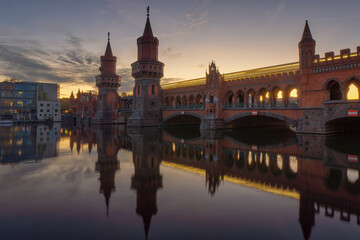 Fototapeta premium Ansicht der Berliner Oberbaumbrücke zum Sonnenuntergang mit einer U Bahn als Langzeitbelichtung