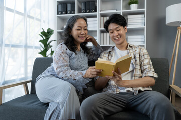family holidays, hobbies Image of two couples, mother and son doing activities together. Reading books, tablets, talking, giving advice, resting, drinking orange juice to relax in the office in house
