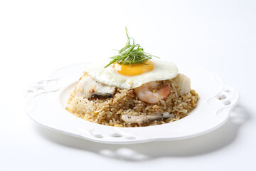 wok garlic fried egg rice with mixed seafood fish, prawn, squid, octopus, fried egg and vegetables in plate on vintage table cloth white background asian chef cuisine halal food menu for cafe