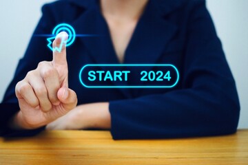 Hand tapping on start button 2024 for happy new year with technology concept Start a new business and a new life.