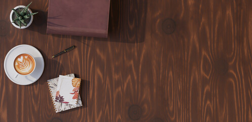 A desktop with coffee, books, pens, and decorations on top. 3d rendering.