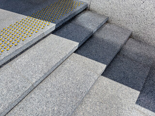 granite staircase with yellow nonskid bumpy markings for visually impaired people.