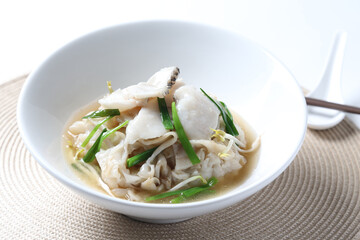 hot wok chinese fried kway teow vermicelli noodle with grouper fish slices and vegetables in thick gravy egg sauce in bowl on brown cloth white background asian chef cuisine halal food menu for cafe