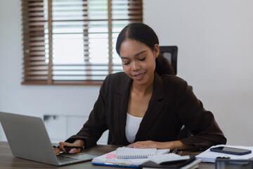 Young African woman with documents finance and laptop working at office, African American working online from home.