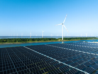 solar power panels and wind turbines on beach