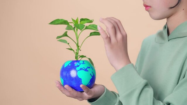 Young Asian girl holding earth drawn plant pot. Environment protection concept.