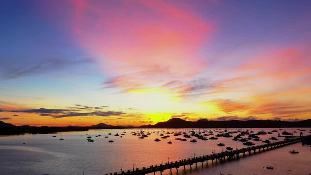 aerial view scenery pink cloud above the island..4K vdo of Majestic sunrise landscape Amazing light of nature cloudscape sky above mountain range. .boats yacht in Chalong marina gulf background..