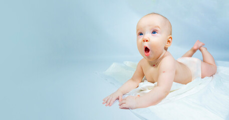 a baby with a hemangioma on his neck lies on a blue background. banner with a copy space. the child yawns sweetly