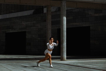 Fototapeta na wymiar Sporty girl performs functional training on the street.