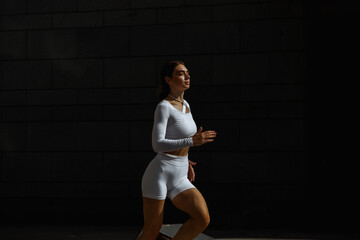 Sporty girl performs functional training on the street.