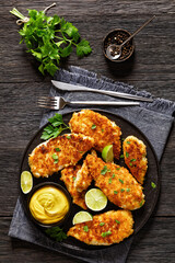 fried chicken cutlets on black plate, top view