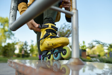 Closeup view on male leg wearing roller skates and hand snapping lock