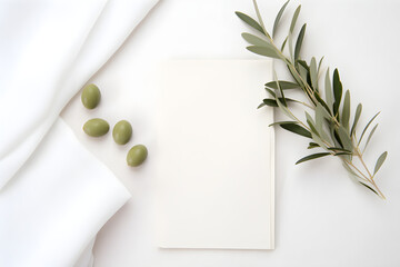 feminine minimalist styled wedding stationery mockup with a stack of blank invitation cards and a fresh olive twig on a white soft linen background