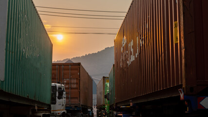 Cargo Container Truck at Ship yard at sunset. Truck transportation export and Import shipping.