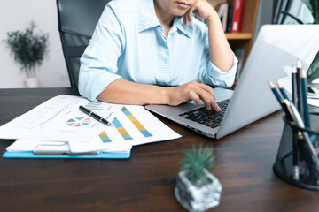 Businesswomen working to analyze, work together to discuss company financial statistics, brainstorm ideas, and graph documents on the table.